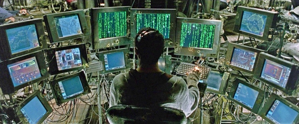 The operator's console of glowing screens aboard the Nebuchadnezzar in The Matrix
